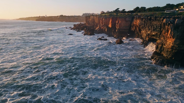 Evening seascape rocky seacoast with foaming waving ocean water aerial view