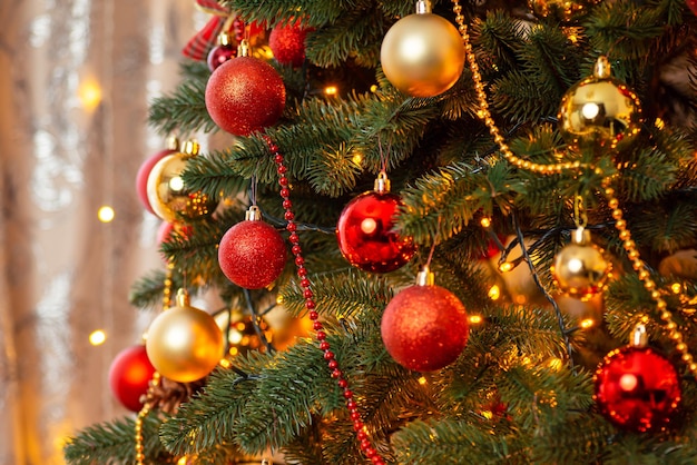 Evening shot of fir tree decorated with bright baubles electric garland lights beads