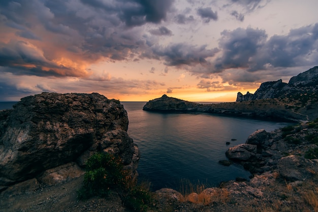 Evening sunset in mountains and the sea with clouds