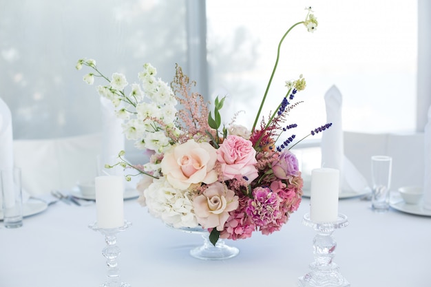 Event white restaurant table served and decorated with delicate fresh flowers