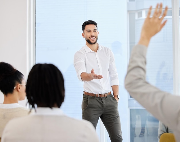 Photo every question has an answer cropped shot of a handsome young businessman gesturing towards a colleague while giving a presentation in the conference room