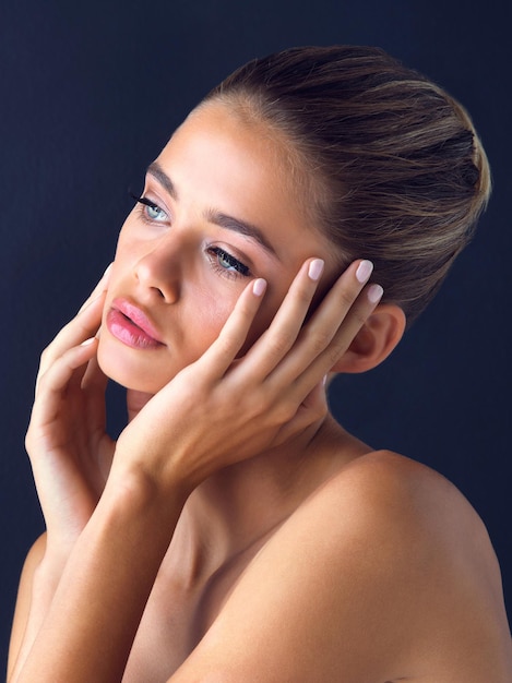 Everyone is beautiful in their own way Studio shot of an attractive young woman posing and touching her face with both hands