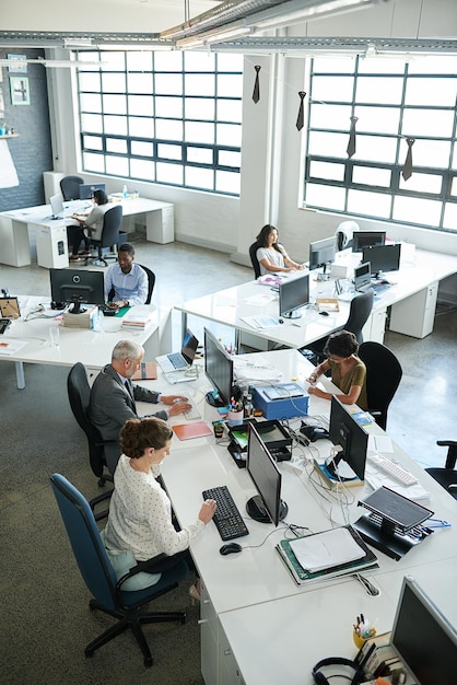 Everyones focused on their tasks Shot of a group of coworkers sitting at their workstations in an office