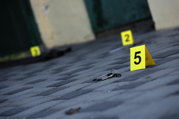 Evidence with yellow CSI marker for evidence numbering on the residental backyard in evening Crime scene investigation concept