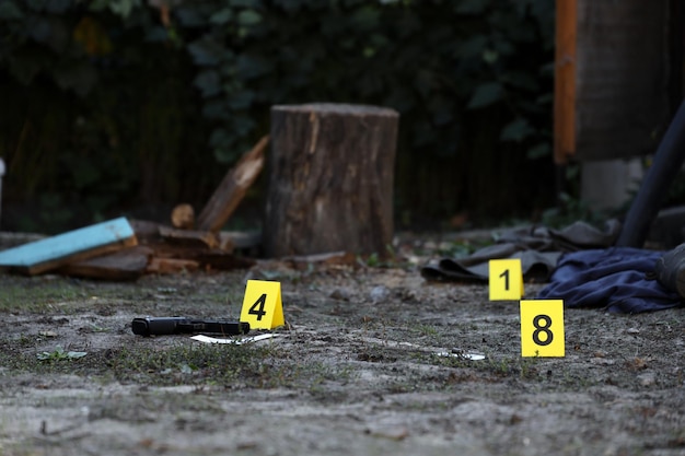 Evidence with yellow CSI marker for evidence numbering on the residental backyard in evening Crime scene investigation concept