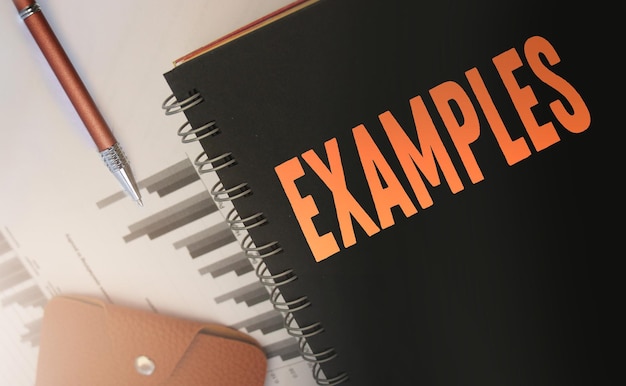 Photo examples word written on a copybook cover orange on black business and education concept selective focus