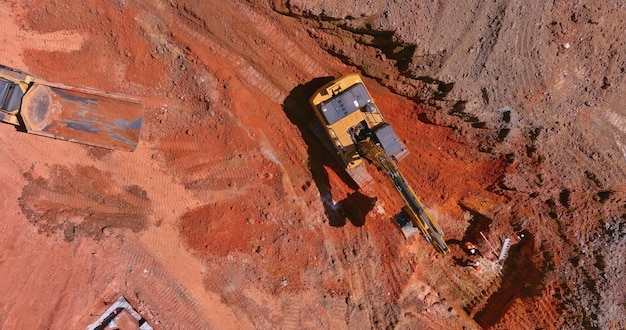 An excavation work is being carried out on a construction site using an excavator for dumping earth for loading into a dump truck