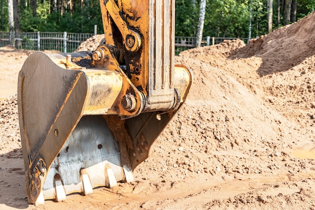 Excavator bucket close up. Excavation work at construction site and road construction. Construction machinery.