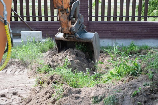 Excavator bucket closeup on the background of a construction site Heavy earthmoving equipment Soil development