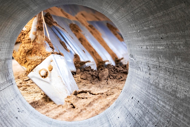 Excavator bucket closeup view from a large diameter pipe Heavy earthmoving equipment Soil development Laying of underground communications