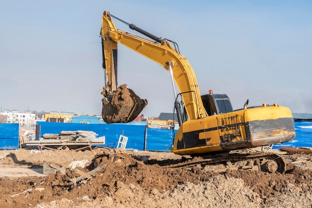 A excavator bulldozer digging dirt ground, shoveling ion the construction site