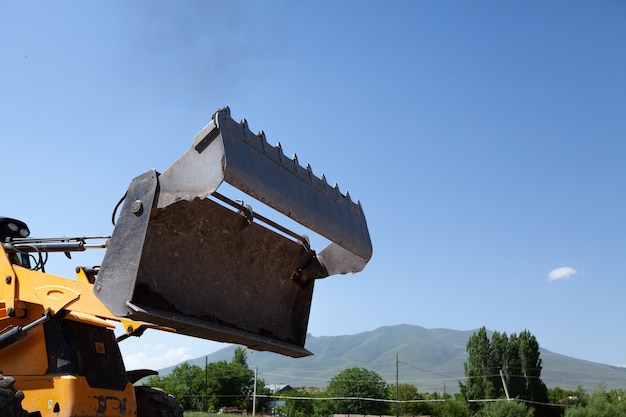 Excavator and new building in the field. build a house