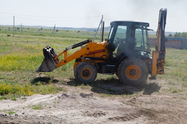 Excavator and new building in the field.