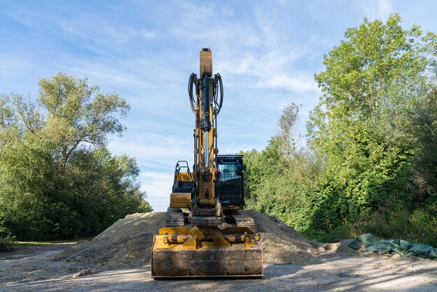 Photo excavator at work moving dirt in a lush green landscape