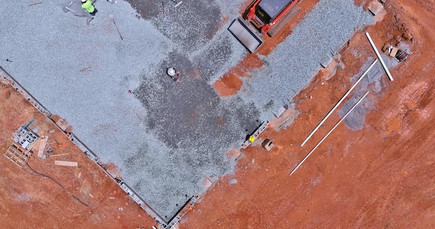 Excavator working in excavator bucket leveling gravel the building foundation on a construction site