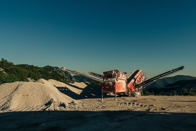 Photo excavators extracts the clay into open industrial quarry