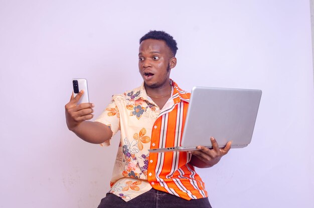 Excited Afro american focused man in eyeglasses working with laptop