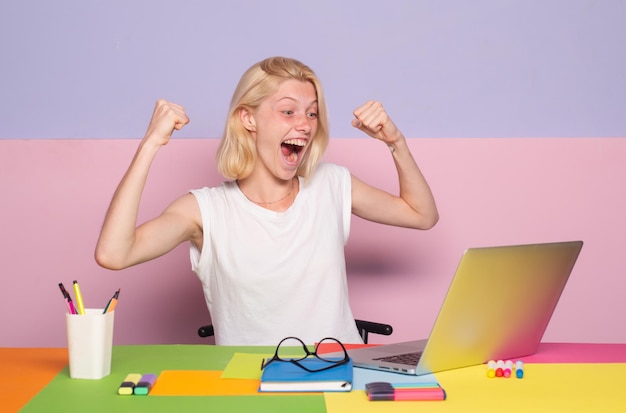 Excited amazed teacher works on laptop shcool teacher in class professional emotional portrait