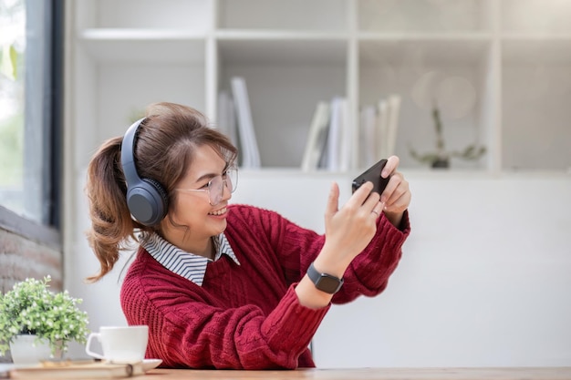 Excited Asian woman playing online game on her smartphone with live broadcasting on internet cell telephone technology ecommerce concept