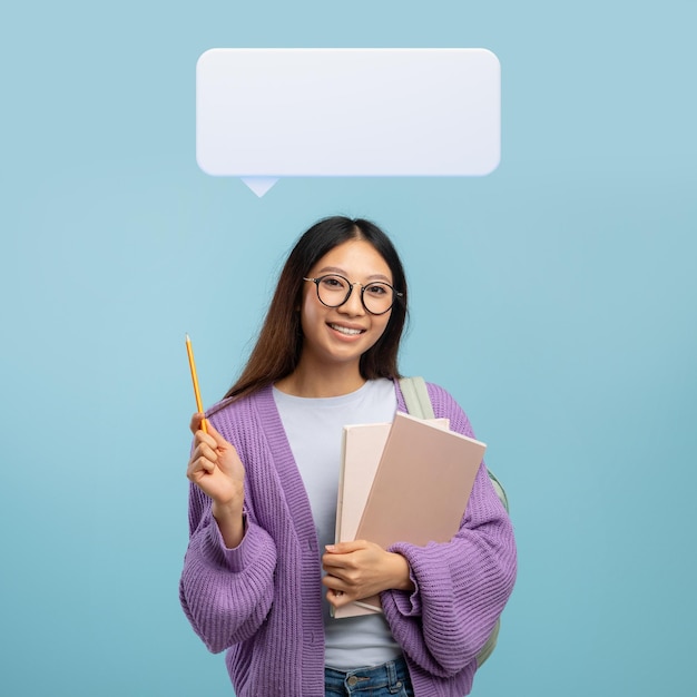 Excited asian woman student pointing pencil up at speech bubble