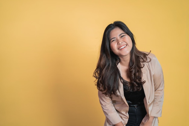 Excited asian woman with long hair smiling while standing