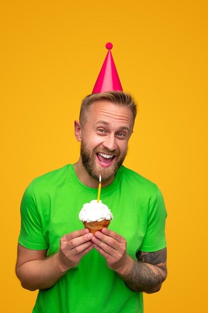 Excited bearded guy with birthday cupcake