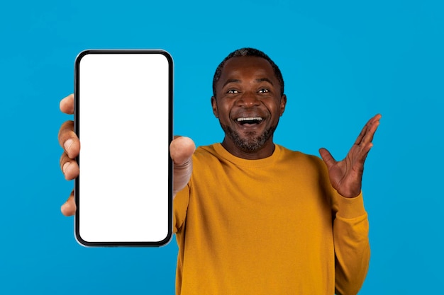 Excited black man showing smartphone with empty screen