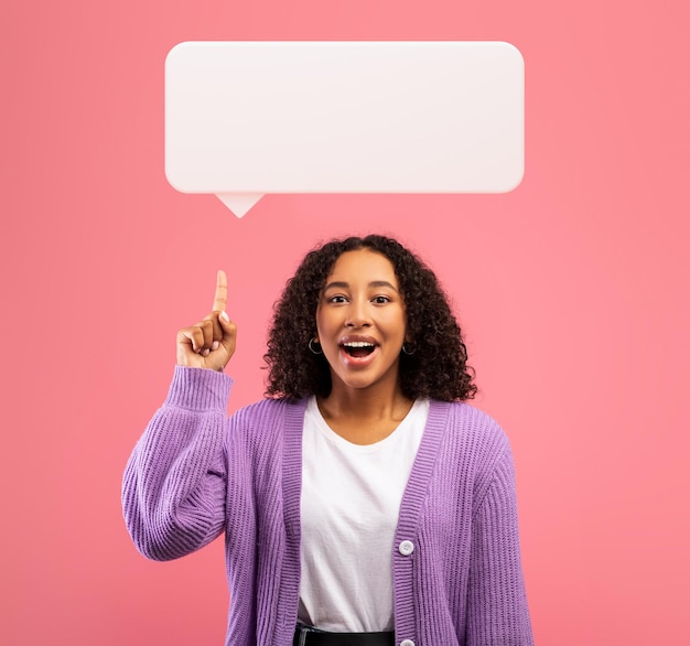 Excited black woman pointing upwards at communication cloud