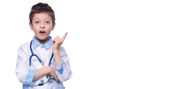 Excited boy doctor with stethoscope finger pointing on product on white isolated background Healthy lifestyle concept