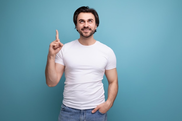 Excited brunette man in white tshirt and jeans pointing finger