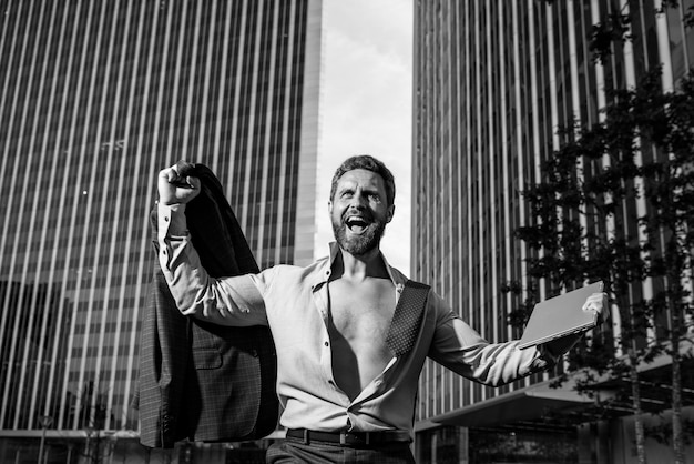 Excited business man model in unbuttoned shirt outdoor