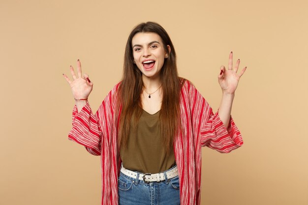 Excited cheerful young woman in casual clothes holding hands in yoga gesture, relaxing meditating isolated on pastel beige background. People sincere emotions, lifestyle concept. Mock up copy space.