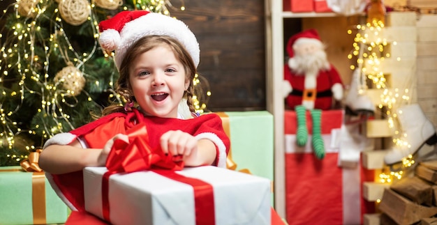 Excited child girl opening a christmas present