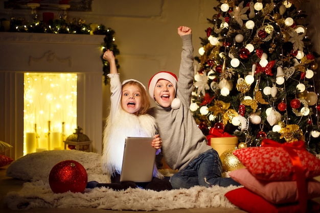 Excited children near Christmas tree