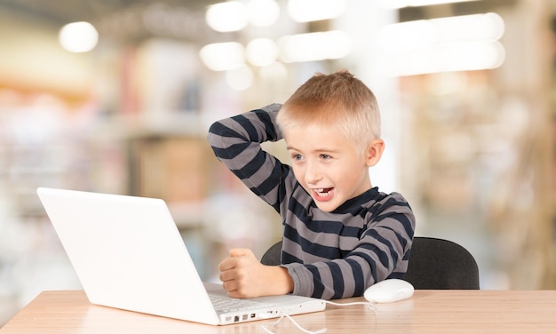 Excited cute Little boy with laptop