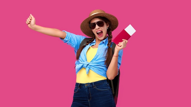 Excited female tourist holding passport and traveling tickets over pink isolate background woman stu