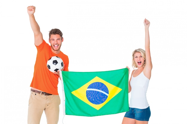 Excited football fan couple holding brazil flag