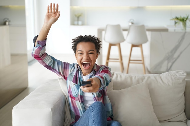 Excited football team fan is relaxing at home watching the game Soccer match watching