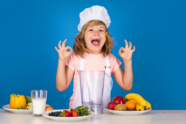 Excited funny chef cook kid boy in chef hat and apron cooking preparing meal little cook with vegeta