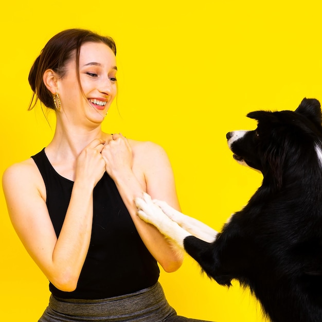 Excited girl dancing with border collie studio portrait lady looking at dog with surprised smile