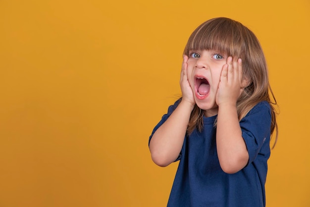 Excited girl screaming on yellow background