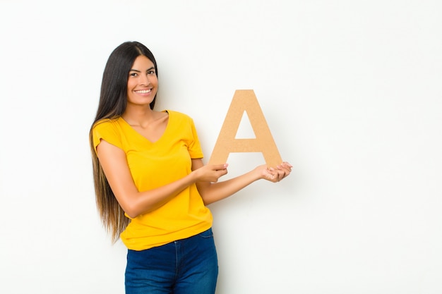 excited, happy, joyful, holding the letter A of the alphabet to form a word or a sentence.