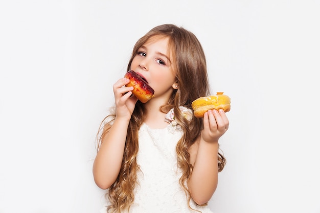 Photo excited little girl posing with donuts