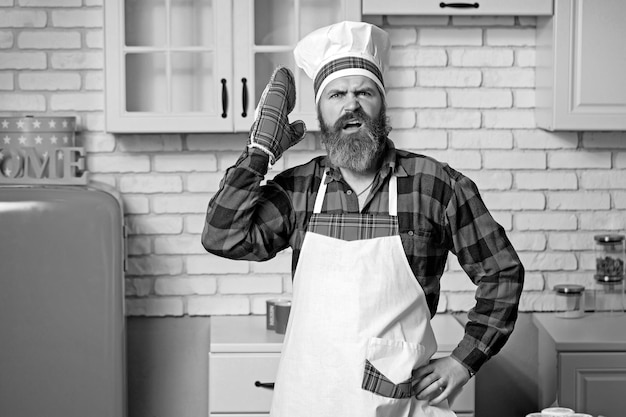 Excited man chef cook wearing uniform showing Masterclass cooking dish