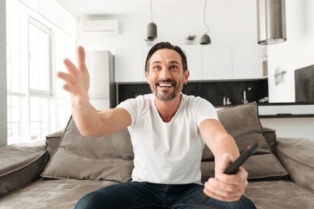 Excited mature man sitting on a sofa