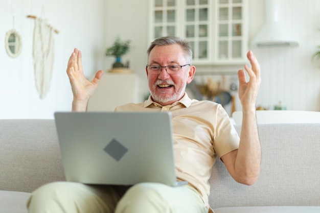 Excited middle aged senior man euphoric winner older mature grandfather looking at laptop reading