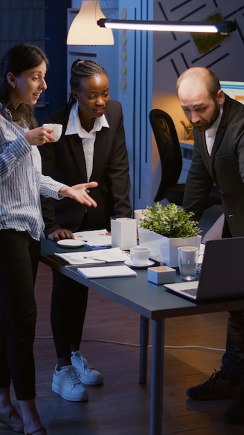 Excited multi ethnic businesspeople receiving good news clapping while standing at table conference