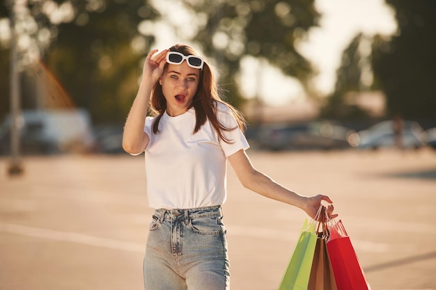 Excited for the sales Beautiful woman in casual clothes is holding shopping bags outdoors