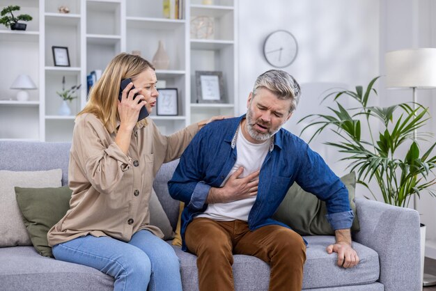 Excited scared wife is calling an ambulance on the phone because her husband is sick he is holding