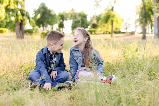 Excited smiling kids in green field play together